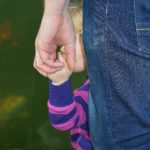 Bébé qui se cache derrière son père