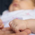 La petite main de Bébé dans cette de Maman