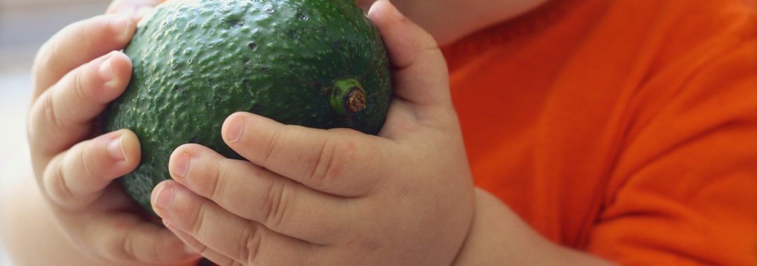 Bébé mangeant un avocat, riche en vitamine b9